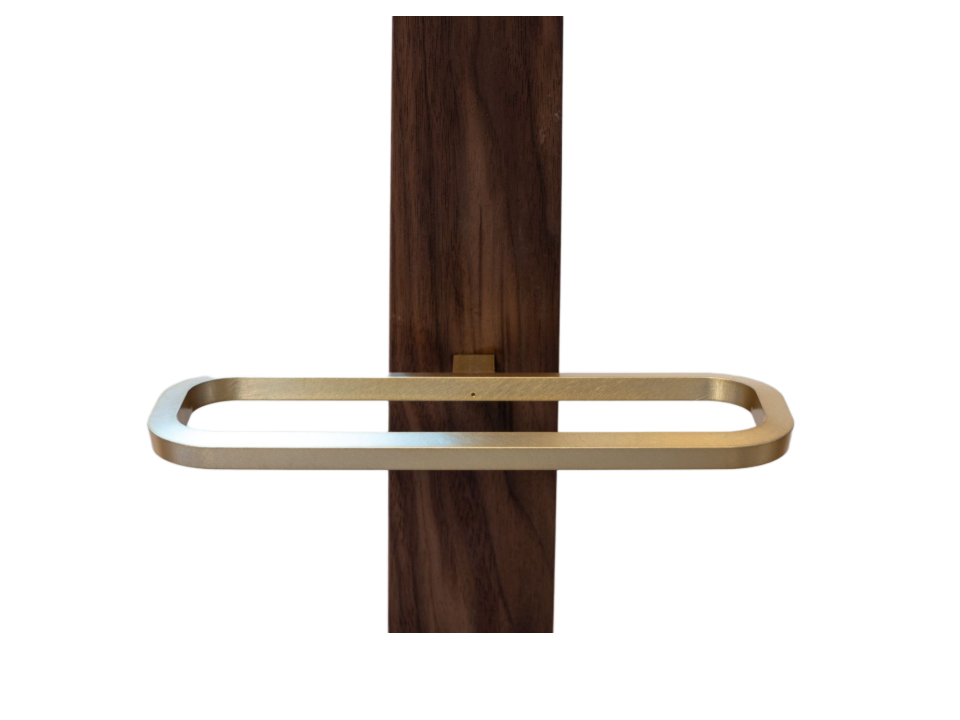 A brass Uva cradle wrapping a walnut column